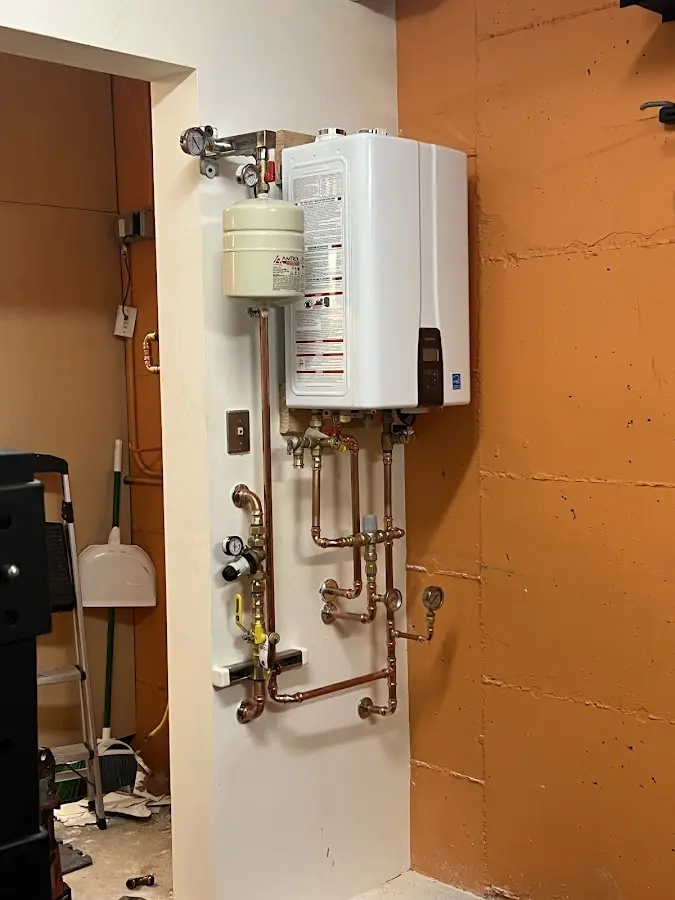Plumbing technician inspecting water heater connections in Jersey Shore